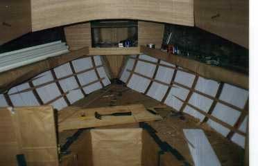 Forward Cabin Insulation – A small shelf was added on both sides of the forward cabin. Notice the frames in place for the ceiling, the roughed-in forepeak locker and the insulation along the hull.