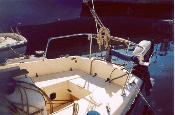 A typical placement of an outboard engine on the port side of the transom. Note the fuel tank storage in the cockpit.